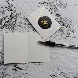 Detailed view of an elegant gold foiled 'Love you' sticker seal on a white envelope set.
