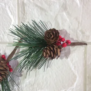 Vista detallada de decoración navideña con agujas de pino y piñas para la mesa