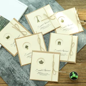 Tarjetas de felicitación vintage de papel kraft con dijes de metal y cuerda de yute natural