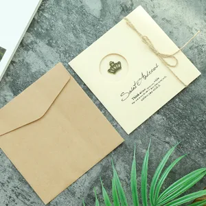 Tarjeta de felicitación vintage con dije de corona y sobre de papel kraft