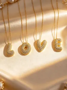 Detailed close-up shot of gold-plated crystal puffy letter pendant necklaces detail.