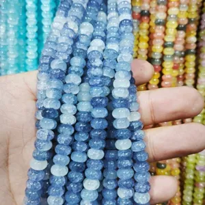 Hand holding strings of blue ice-cracked 4x8mm rondelle beads for handmade DIY jewelry