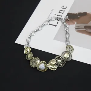 Detail van vintage punk choker van titaniumstaal met antieke koperen knoopbedels.