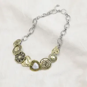 Detailopname van vintage koperen knoopbedels aan een punk titanium stalen ketting