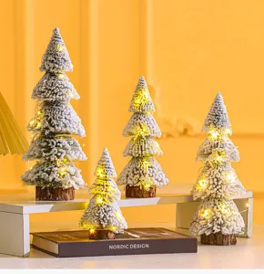 Set of mini flocked cedar Christmas trees with LED lights on a Nordic display stand