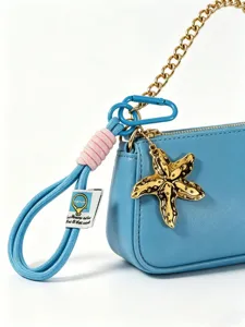 Borsa a tracolla in pelle PU blu con catena dorata, ciondolo stella marina e laccetto intrecciato.