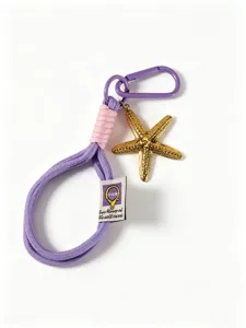 Primo piano di un cordino intrecciato viola e rosa con ciondolo a forma di stella marina.