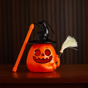 Nahaufnahme einer festlichen Halloween-Kürbis-Laterne mit Hexenhut und Besen-Detail