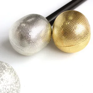 Close-up of gold and silver textured microphone toy heads for kids' performance