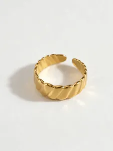 Close-up detail shot of a stylish gold-plated geometric wavy open ring for women.