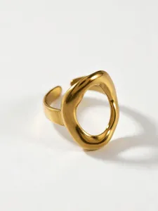 Close-up detail of trendy gold geometric open ring, modern stainless steel cutout design.