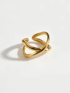 Detailed shot of a stylish gold geometric cross-shaped open ring, sleek modern jewelry design.
