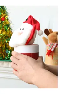 Nahaufnahme eines weichen Weihnachtsmann-Deckels auf einer roten Geschenkbox.