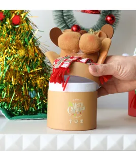 Detailaufnahme einer zylindrischen Weihnachtsgeschenkbox mit einem süßen Elchplüsch