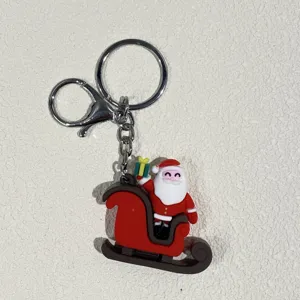 Detailansicht des Weihnachtsmanns im roten Schlitten Schlüsselanhänger mit Silberring.