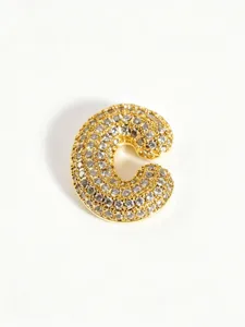 Close-up detail shot of a gold-plated bubble letter C pendant pavéd with sparkling rhinestones.