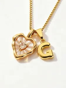 Detailed close-up of gold stainless steel heart mother-of-pearl necklace with letter G pendant.
