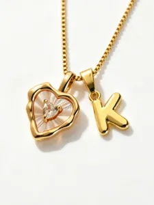 Gold stainless steel box chain necklace with mother-of-pearl heart pendant and letter K charm.