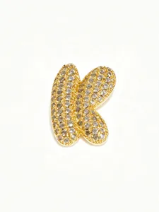 Closeup of a gold bubble letter K pendant, fully paved with sparkling stones for a chic look.