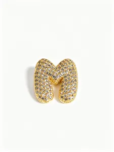 Gold bubble letter M pendant detail, micro pavé crystal paved stainless steel jewelry piece.