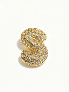 Close-up of a gold-plated bubble letter S pendant sparkling with pave set clear rhinestones.