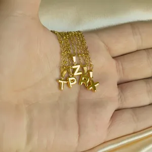 Minimalist gold stainless steel bubble letter pendant necklace showcasing delicate style.