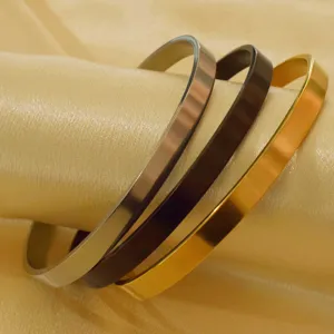 Set of three minimalist stainless steel C-shaped open bangles in gold, black, and silver.