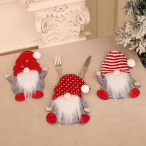 Detailed view of three festive Christmas gnome cutlery holders on a beige table cloth