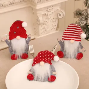 Detailed view of three festive Christmas gnome cutlery holders on a dining table