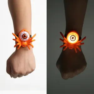 Close-up of a glowing Halloween spider wristband featuring a spooky eyeball design