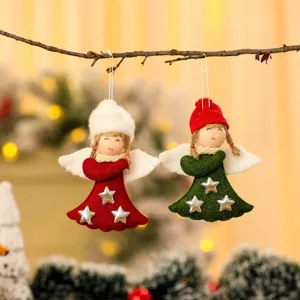 Close-up van schattige rode en groene vilten engeltjes die aan een tak hangen voor Kerst.