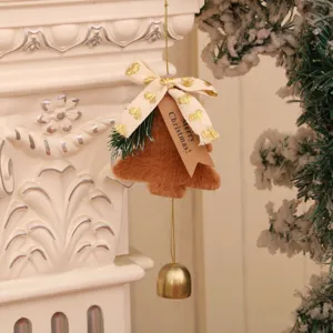Nahaufnahme von plüschigem Weihnachtsbaum-Anhänger mit goldener Glocke und Grußkarten-Schild.