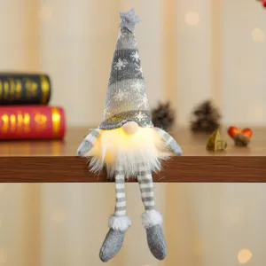 Handgemaakte kerstkabouter met warm licht en gestreepte gebreide muts met sneeuwvlokpatroon
