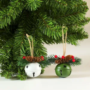 Dekorative Weihnachtsglocken-Anhänger mit Tannenzapfen und roten Beeren am Baum.