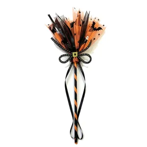 Close-up detail of Halloween witch broom featuring orange tulle and black bat patterns