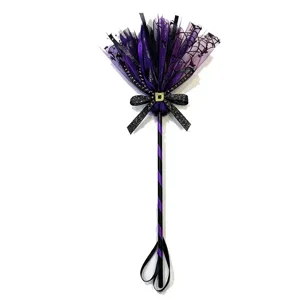 Detail of purple and black Halloween witch broom with spider web tulle and glittery bow