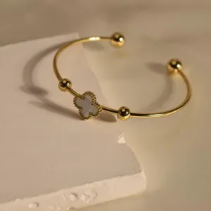 Elegant gold stainless steel four-leaf clover open cuff bracelet with white shell.