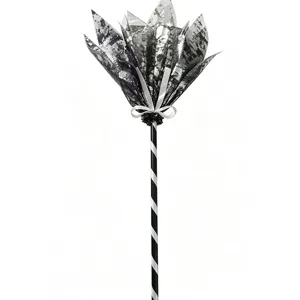Detailed view of Halloween witch broom with striped handle and silver fabric bow