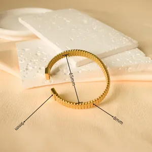 Bracciale rigido aperto intrecciato in acciaio inossidabile dorato, gioiello elegante.