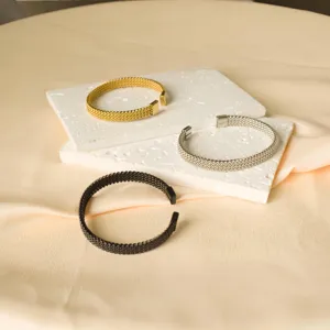 Vista di dettaglio del bracciale rigido aperto in maglia di acciaio inox elegante.