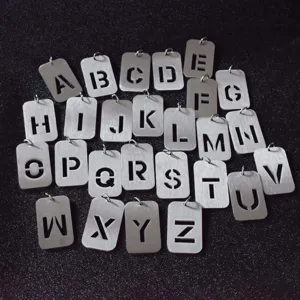 Detail view of 26 alphabet square metal pendant set, brushed silver titanium steel fashion jewelry.