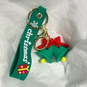 Nahaufnahme eines festlichen grünen Weihnachtsglocken-Schlüsselanhängers mit roter Schleife.