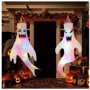 Paar leuchtende Halloween-Gespenster-Windsäcke an einer Tür mit Kürbislichtern
