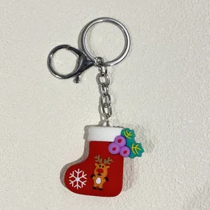 Detailansicht eines roten Weihnachtssocken-Schlüsselanhängers mit Rentier und Flocke