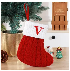 Close-up of a festive red knitted Christmas stocking with an embroidered red letter V detail