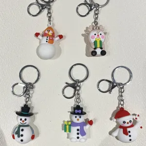 Detailansicht bunter PVC-Weihnachtsschlüsselanhänger mit süßen Schneemännern und Rentieren
