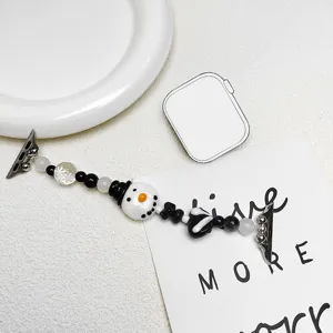 Detailansicht eines Perlenarmbandes mit Schneemann-Motiv und schwarz-weißen Perlen.