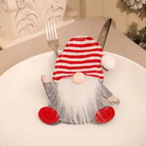 Close-up of a festive gnome cutlery holder on a white plate for Christmas dinner decor