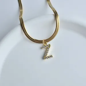 Close-up detail of the elegant gold snake chain necklace featuring a sparkling zircon letter Z.