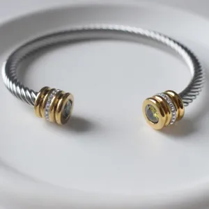 Edelstahl Kabel Armreif mit goldfarbenen Endkappen und funkelnden Strasssteinen eleganter Stil